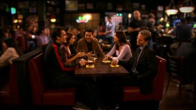 Eine Gruppe Jugendlicher sitzt in einer Bar zusammen.